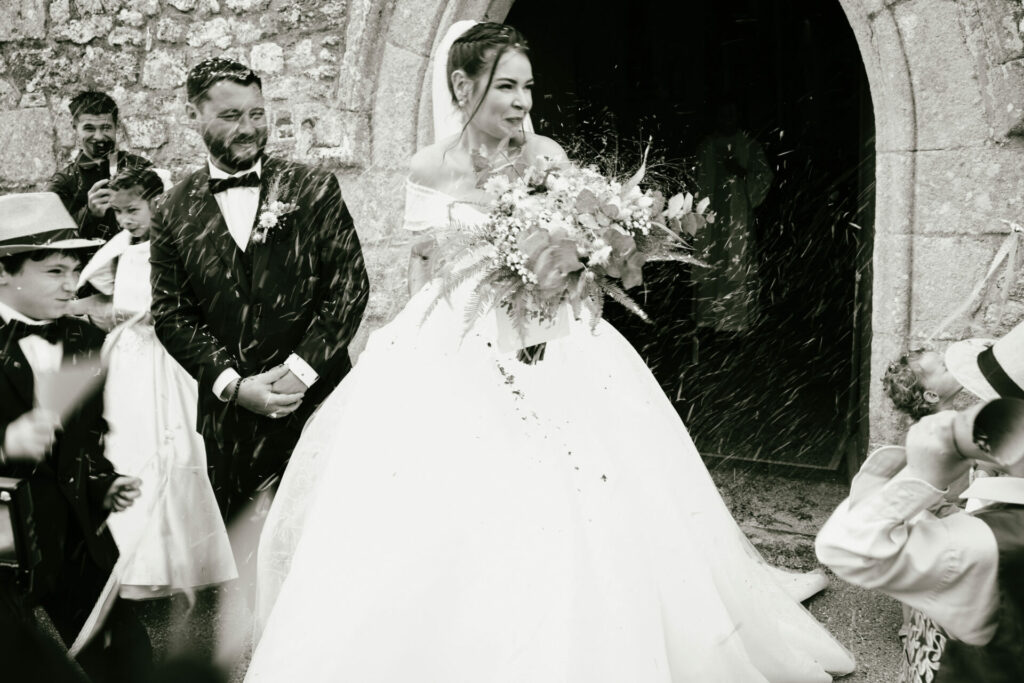 Photographe de mariage capturant une cérémonie à la sortie de l'église