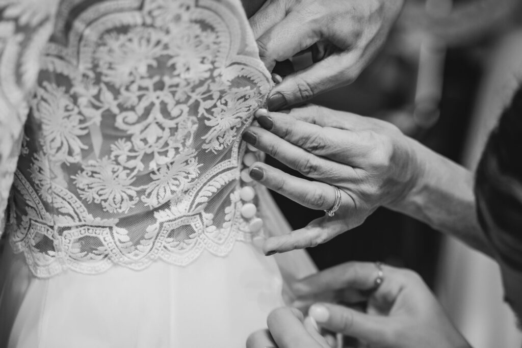 boutonnage de la robe de mariée par la maman