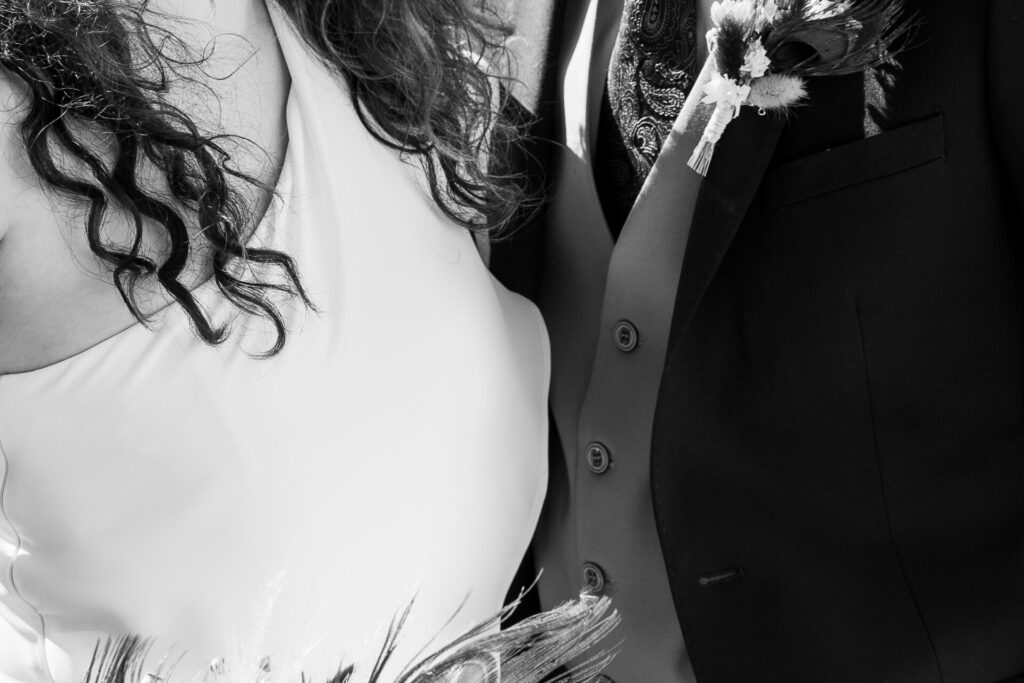 détail de la robe de la mariée et du costume du marié