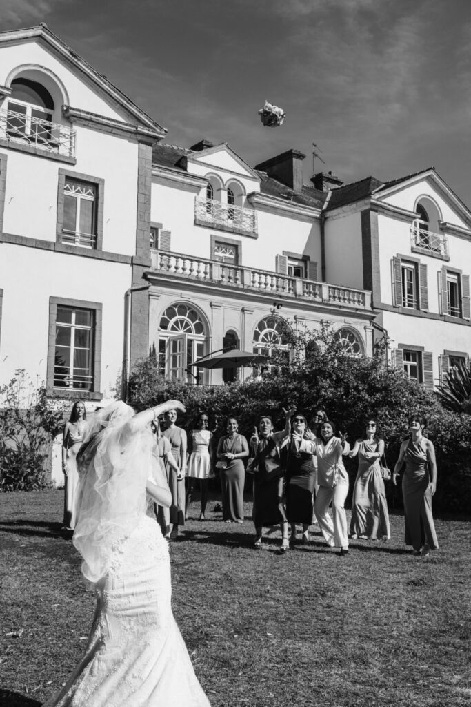 photo du lancer de bouquet de la mariée devant le château de la Guerche à Saint Helen