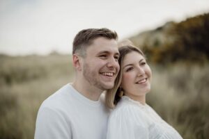 un couple regardant vers l'avenir ensemble dans les dune en bord de mer en Bretagne